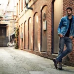Man wearing skinny jeans styled for travel in a modern city
